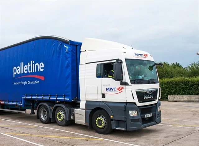 MWT-branded articulated lorry with a blue Palletline trailer parked in a lot, featuring ‘Network Freight Distribution’ branding on the curtain side.